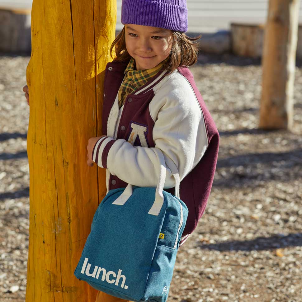 a Kid holding  Cypress green lunch bag by fluf