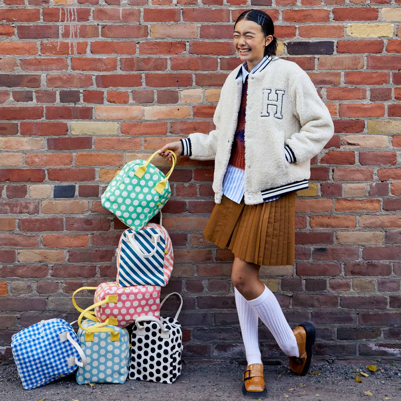 teenager near pile of polka dot lunch bags 